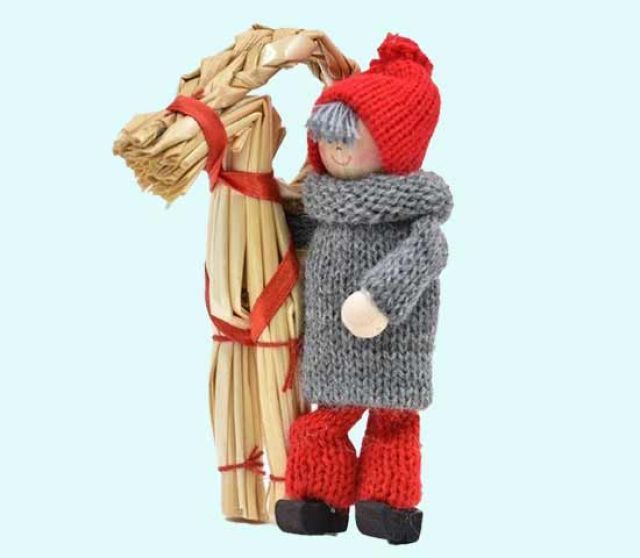 Tomte boy standing w/ straw goat